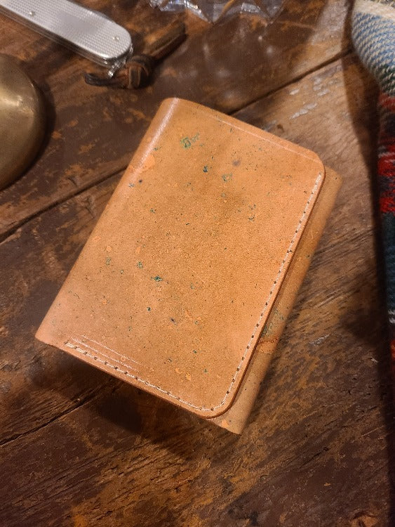 Natural vachetta leather trifold wallet, closed.