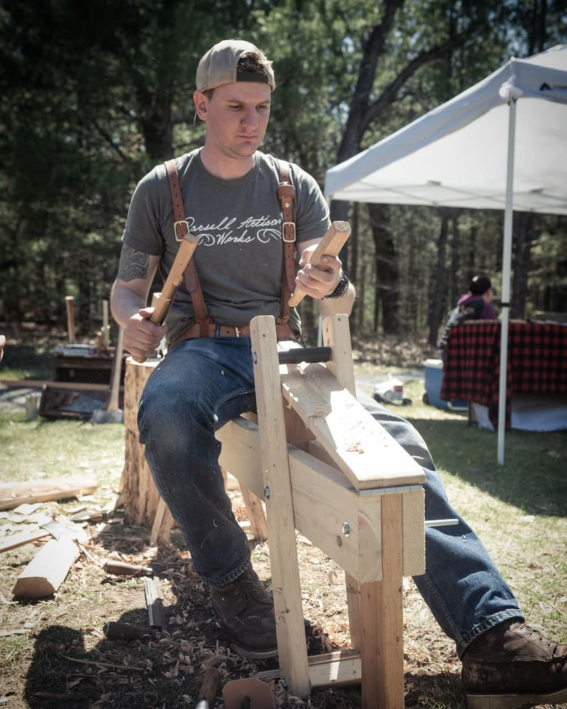 Tim Parsell, leatherworker in Alpena, Michigan. Tim makes leather goods and custom axes. Image is Tim hand carving a handle.